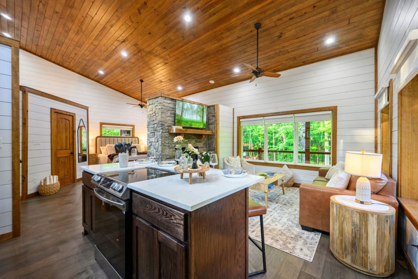 The open-concept flow of this place is so good that you'll find yourself naturally drifting between cooking, lounging by the fireplace, and soaking in those forest views without ever feeling like you're leaving the party.