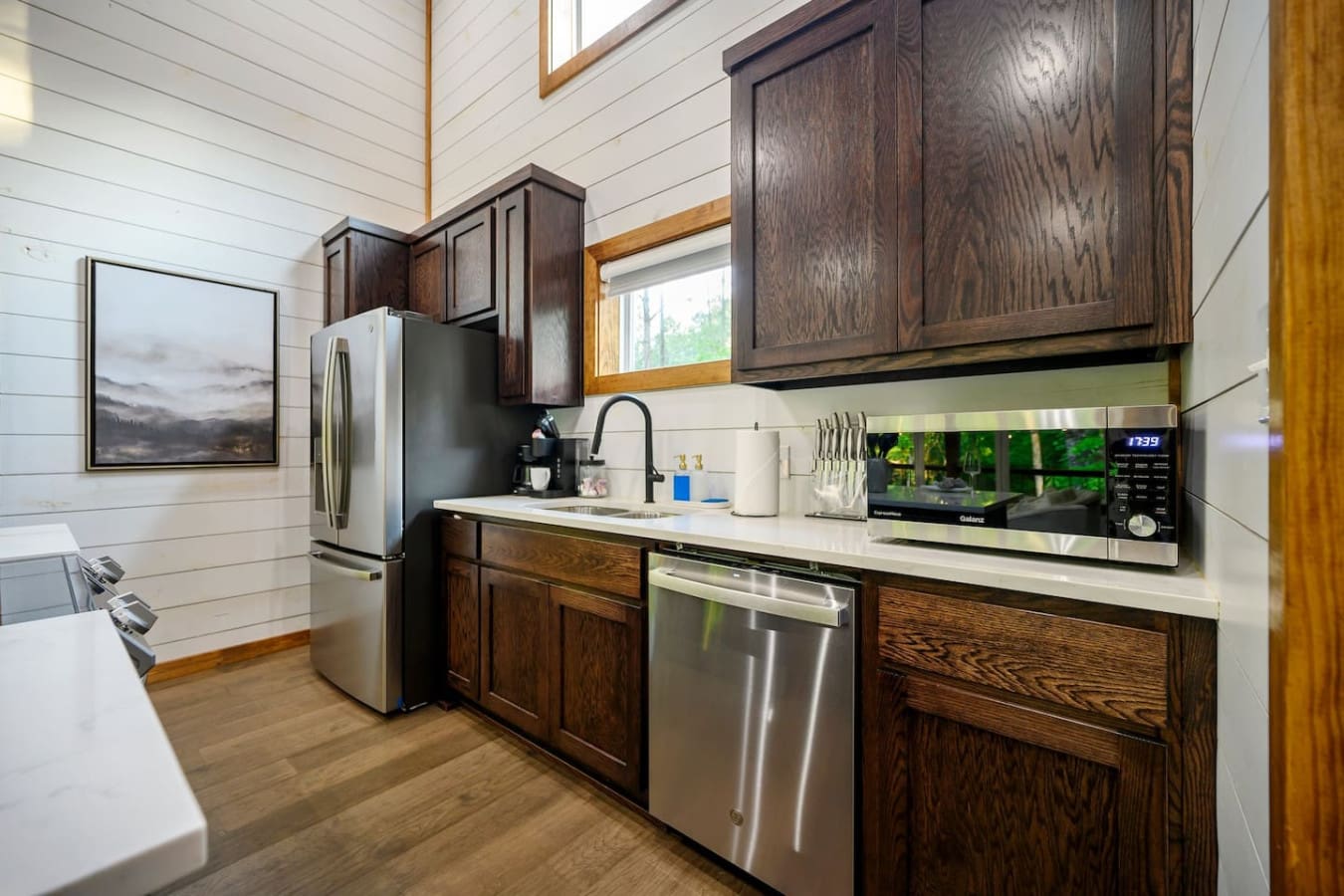 The galley kitchen's got all the essentials packed into a smart layout—stainless steel appliances, solid countertop space, and those dark wood cabinets that give the whole place a cozy, put-together feel.