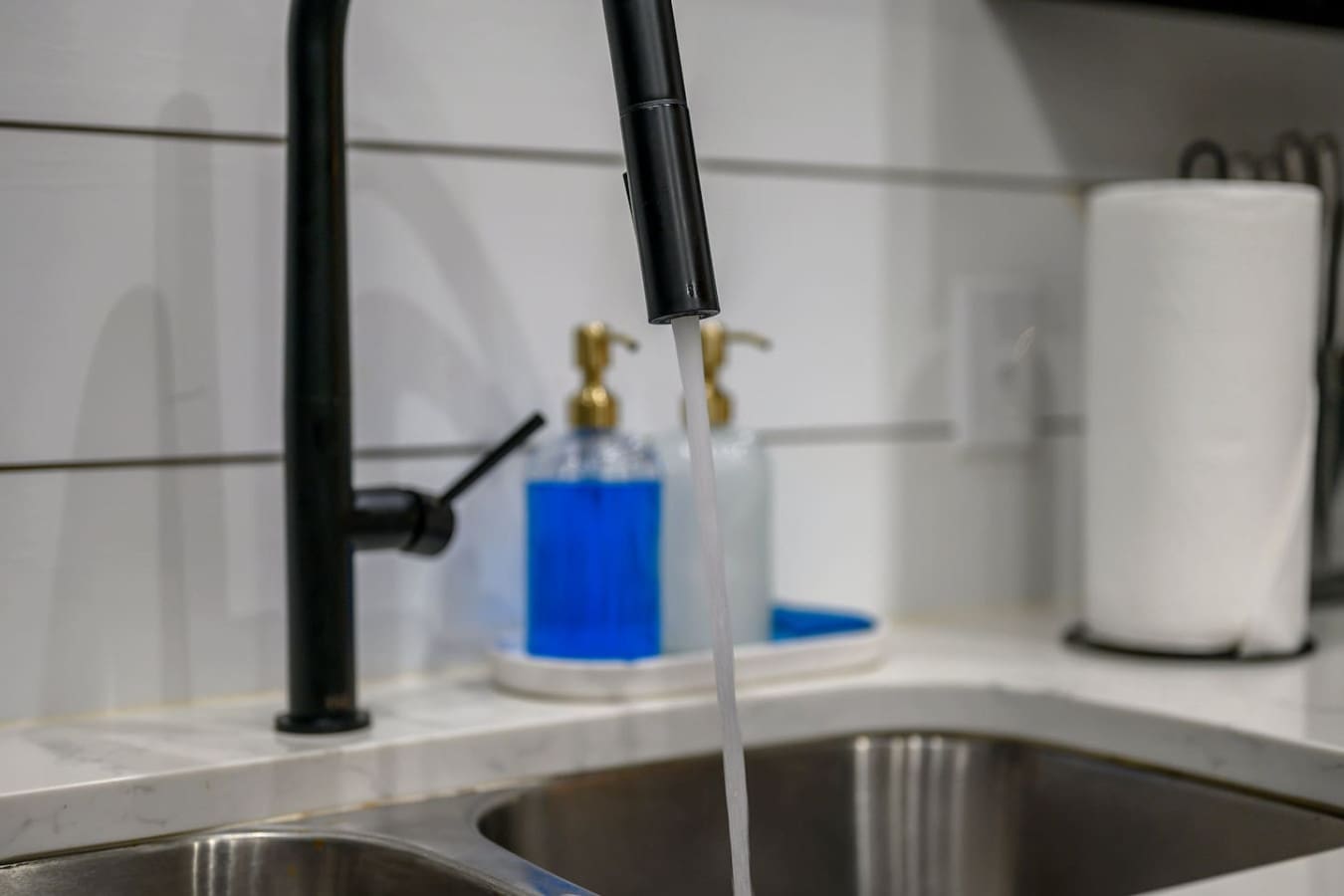 The kitchen's got that sleek black faucet and dual sinks setup that makes cooking and cleanup feel way less like a hassle, especially when you've got company hanging around.