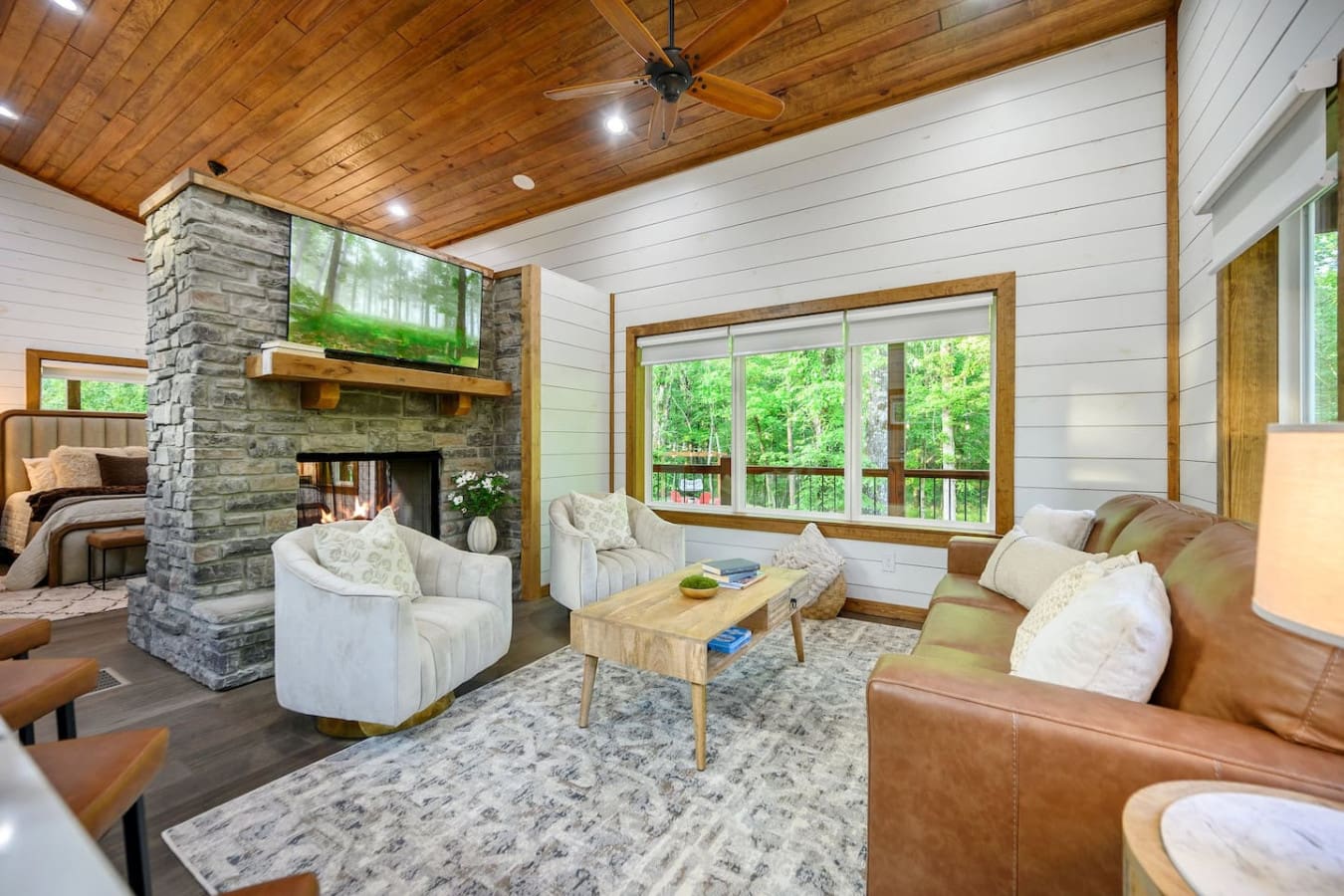 The stone fireplace, leather seating, and those massive windows create the perfect setup for claiming your favorite spot and genuinely not moving for hours.