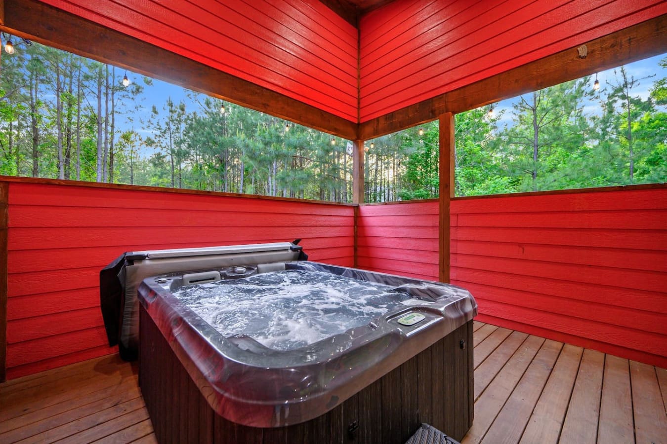 Sink into this hot tub on your private covered deck and let the bubbling warmth, forest views, and that bold red ceiling create the kind of moment where you completely lose track of time.