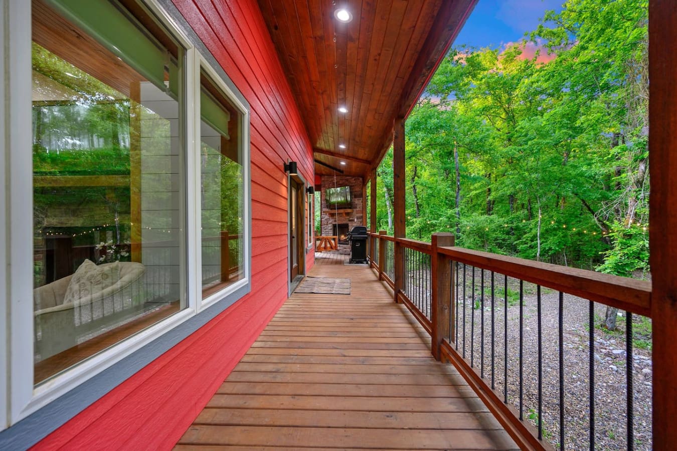 Step out onto this covered deck and you'll immediately understand why "Lil Red" feels like your own private treehouse—the covered ceiling keeps you dry while the forest wraps around you, and there's plenty of room to spread out and just breathe in all tha