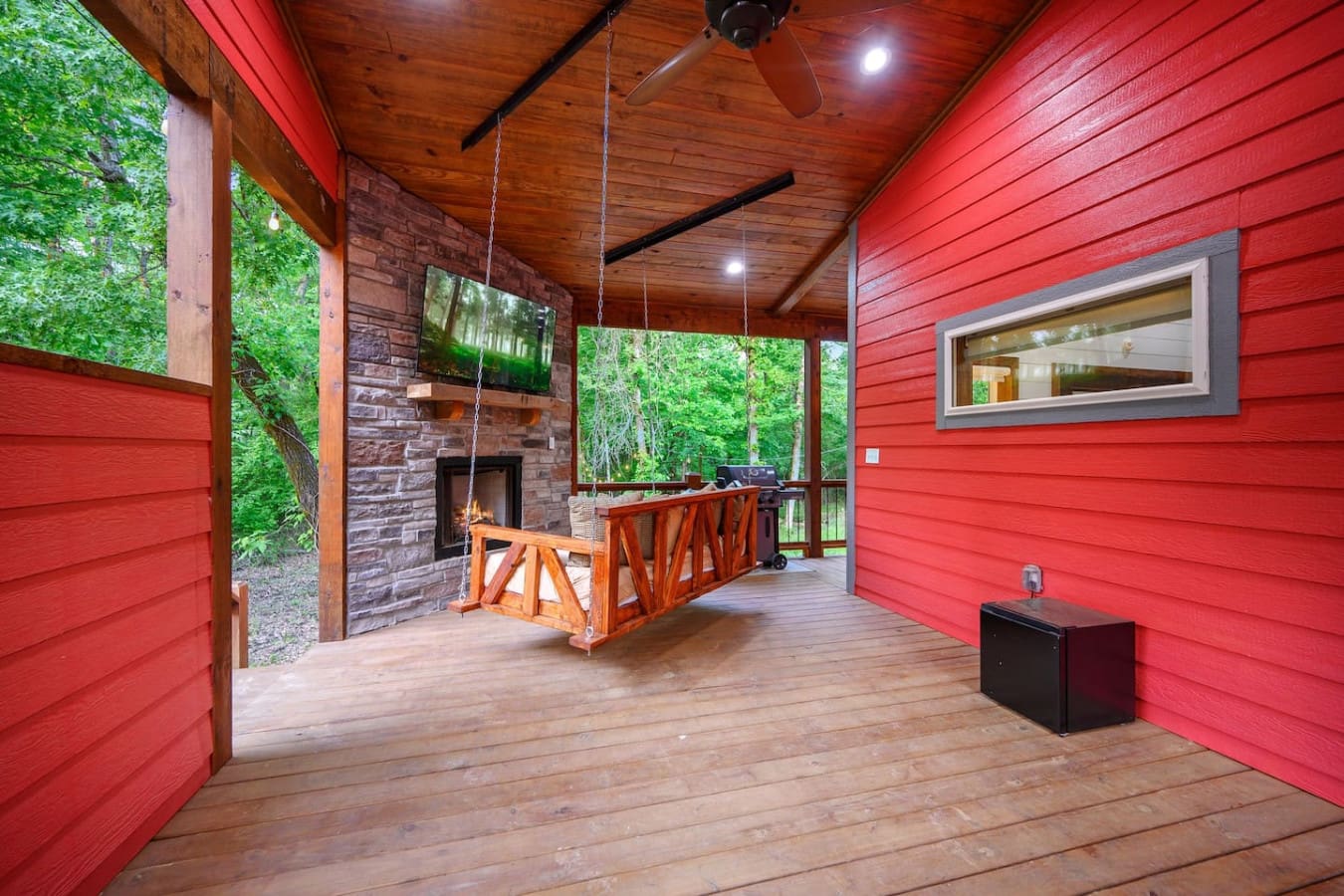 This covered deck is basically your own slice of forest living—complete with a fireplace, TV, and enough space to spread out without ever feeling like you have to choose between comfort and that immersive tree-surrounded vibe.