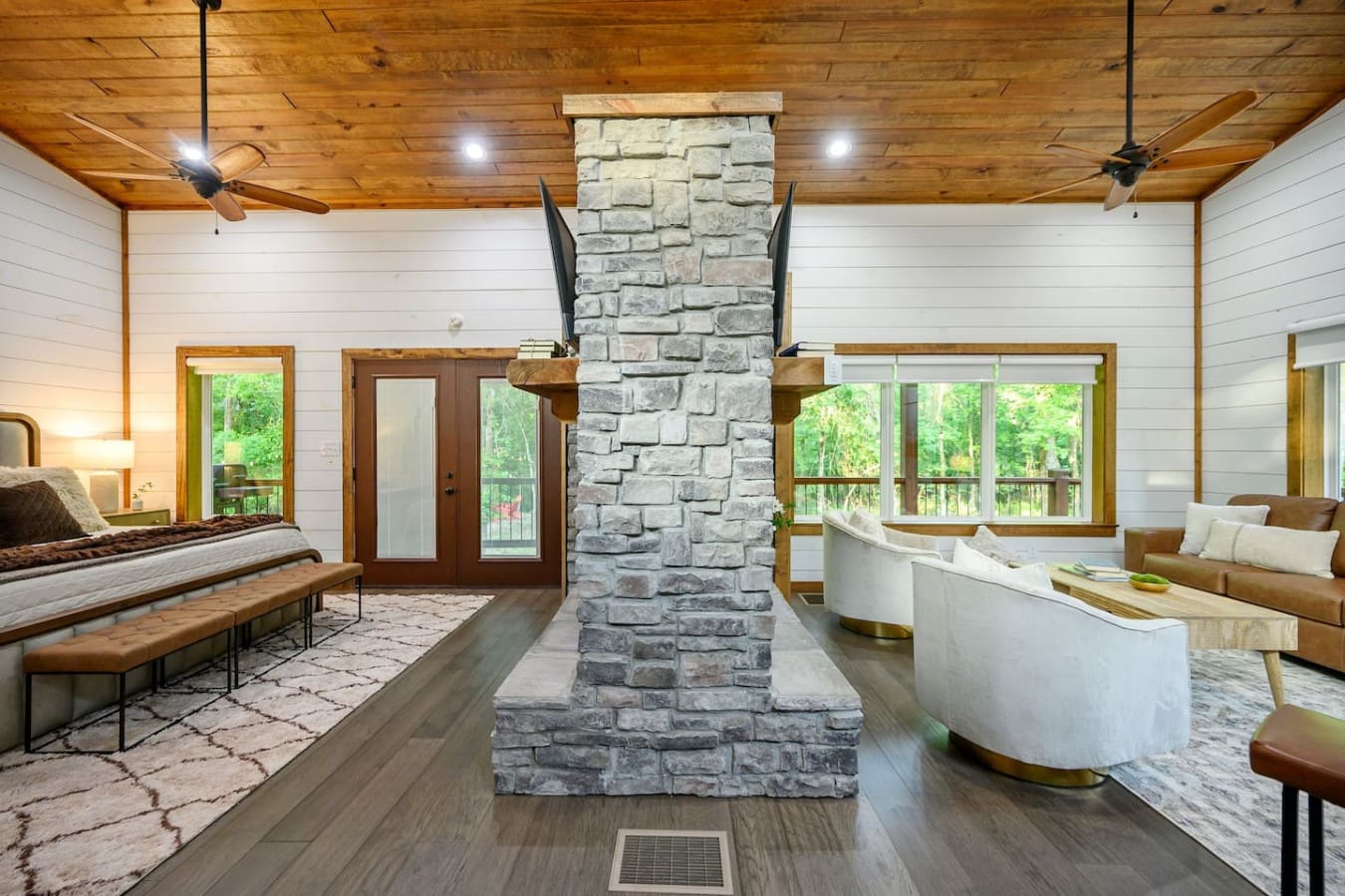 This central stone fireplace is basically the anchor that ties the whole open-concept space together, creating natural gathering zones on both sides without feeling cramped or disconnected.
