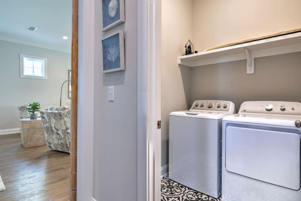 Your laundry room setup is seriously clutch—spacious shelving, modern machines, and enough room to actually fold things without feeling cramped.
