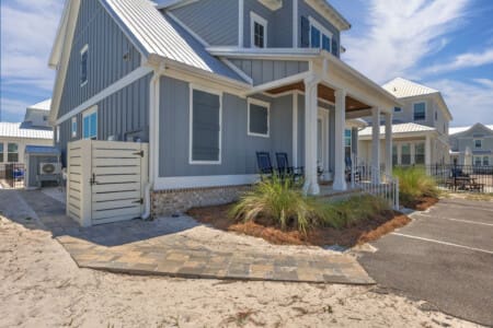 This modern beach cottage with its crisp blue-and-white exterior, welcoming covered porch, and prime location right near the sand is basically your ticket to the ultimate coastal escape.