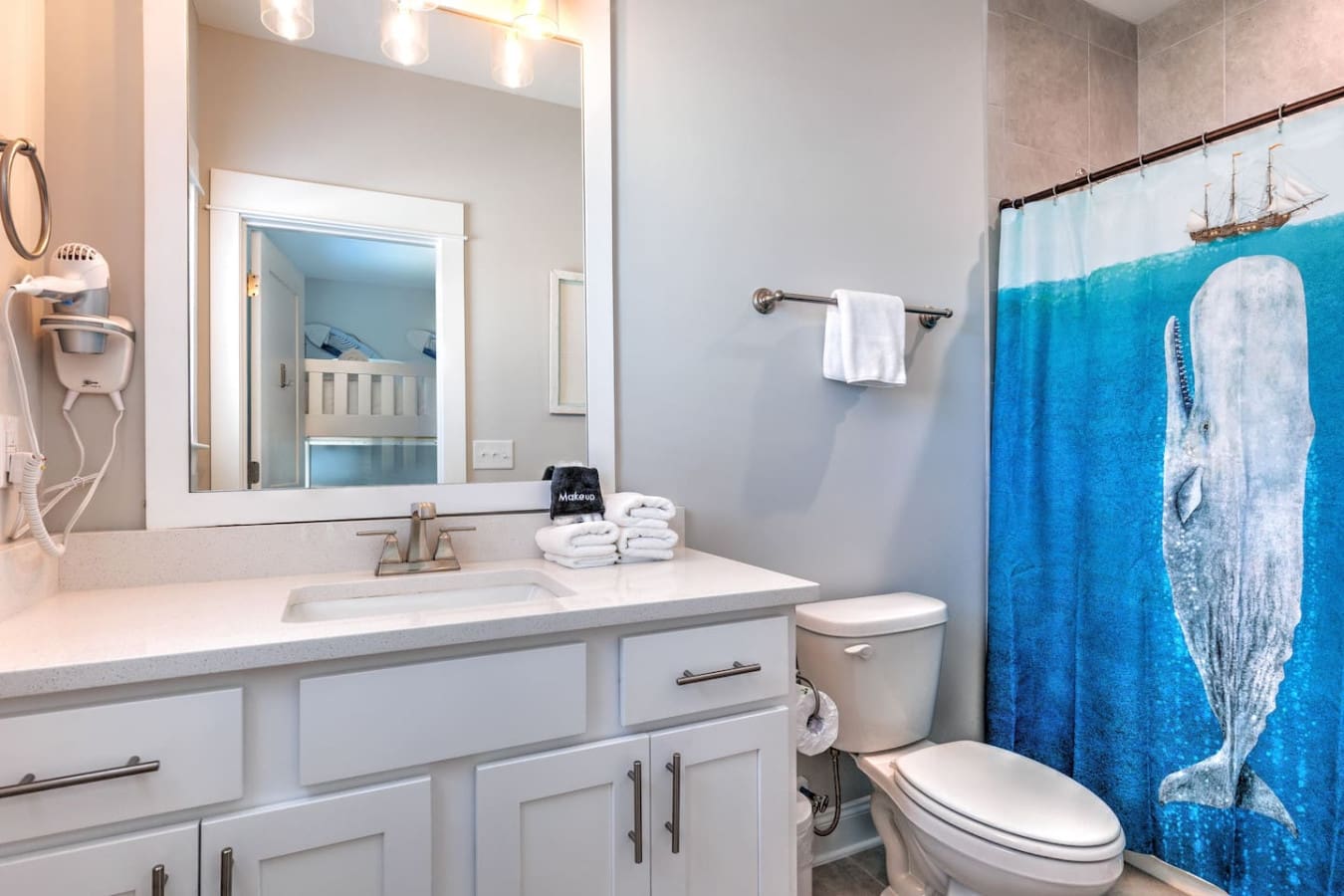 This bathroom's got all the essentials down—a huge vanity, a killer walk-in shower, and that fun whale shower curtain that gives major coastal vibes without taking itself too seriously.