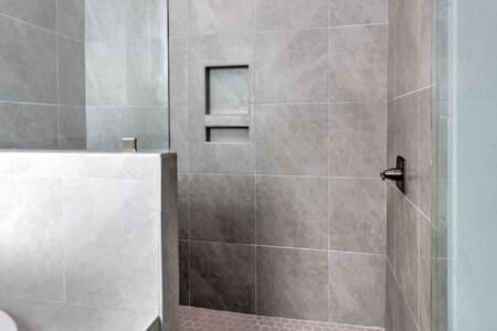 This sleek walk-in shower setup with those built-in niches and hexagon tile floor is basically everything you need to feel put-together during your stay.