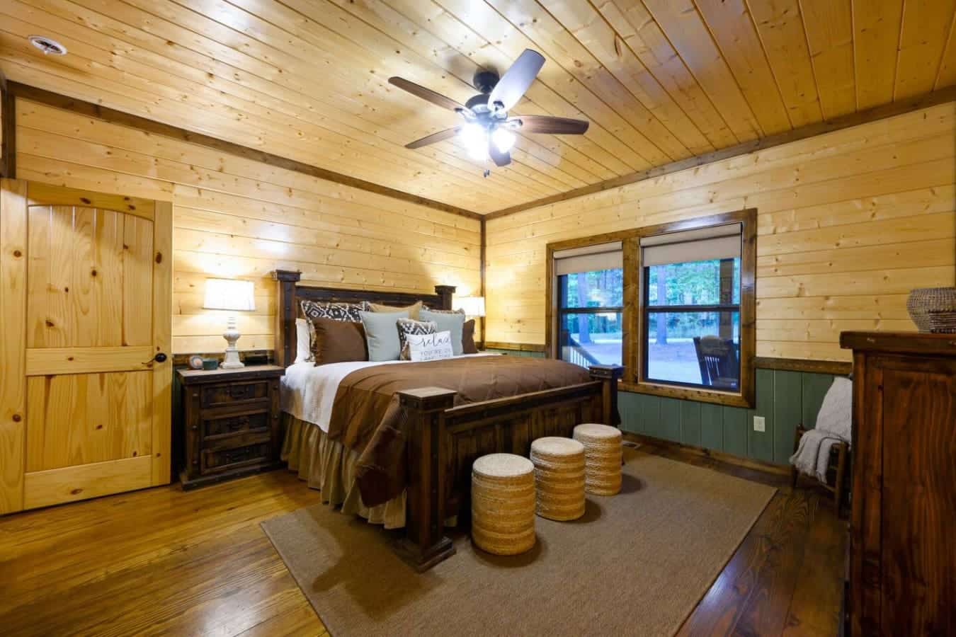 This master bedroom is basically your own treehouse setup with the wood ceiling, dark wood bed, and those big windows that'll have you waking up wondering why you ever sleep in the city.