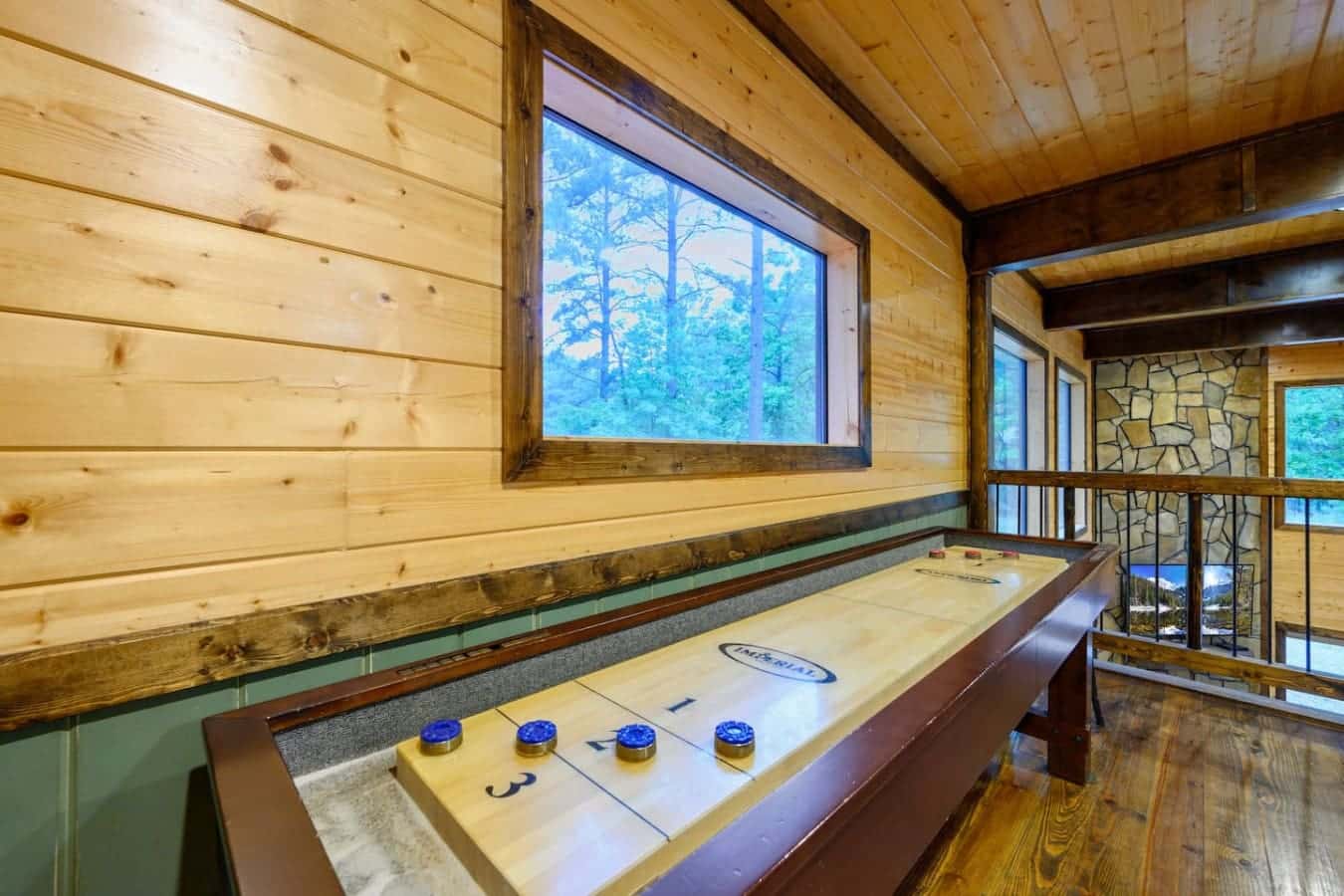 You can settle your shuffleboard beef without leaving the cabin, and yeah, those big windows mean you're not stuck staring at wood paneling the whole time.