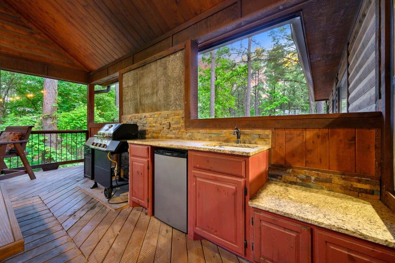 Cook up some burgers on the grill while the forest just sits there and does its thing—this covered outdoor kitchen is basically an extension of the house without any of the walls getting in the way.