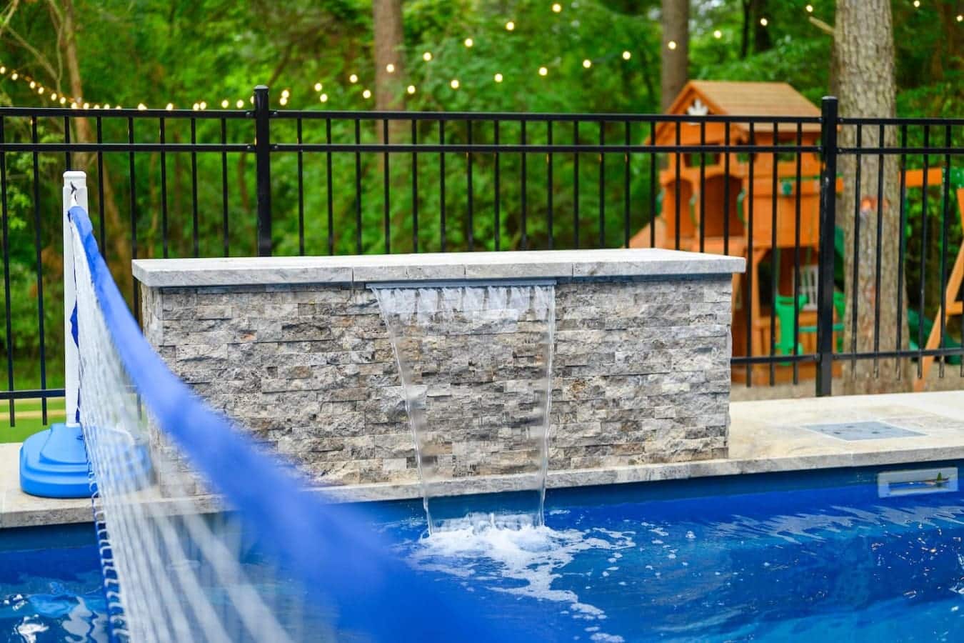This backyard setup is basically built for those long, lazy days where you just float around, watch the water cascade down, and pretend the rest of the world doesn't exist.