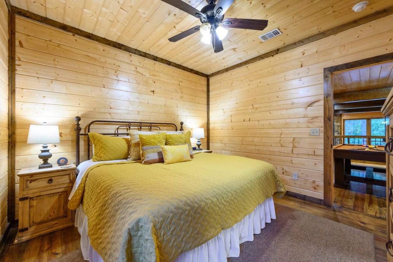 Wake up in this cozy wood-paneled bedroom with that yellow bedding catching all the morning light, and you're already halfway to forgetting why you ever liked your regular bed at home.