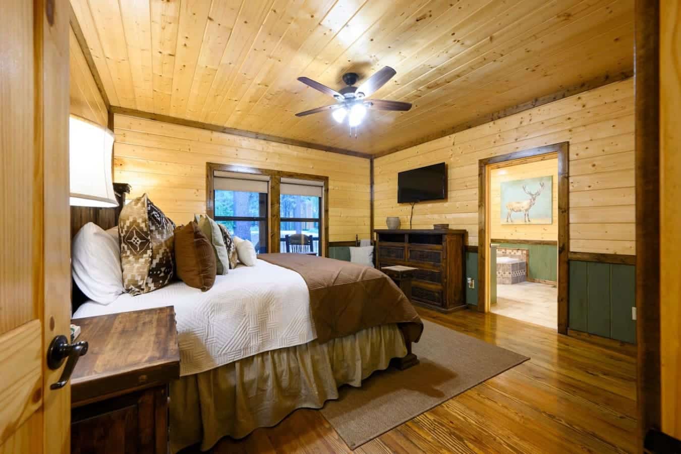 Wake up in this wood-cabin bedroom and you've basically got your own private retreat with a bed that actually fits, a TV if you need it, and windows that do all the heavy lifting on the whole "getting away from it all" vibe.
