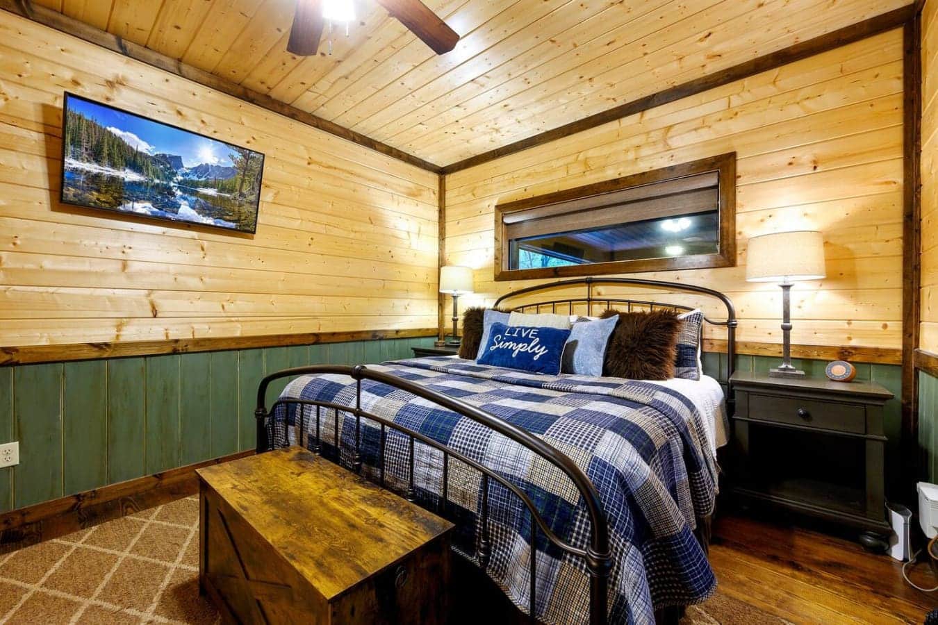 This bedroom's got that cozy cabin energy with the wood everywhere, a metal bed frame that looks like it belongs in a lodge, and enough windows to remind you why you came here in the first place.