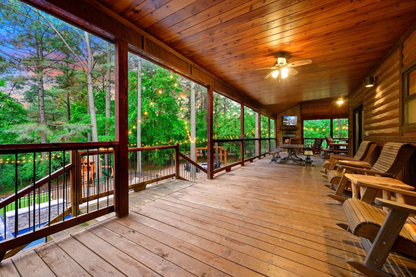 This screened porch is basically your living room now—it's got the fireplace, the views, the lighting, and enough comfortable space that you might genuinely forget the actual cabin exists.