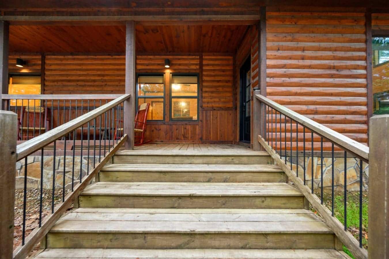 Walk up these stairs and you're basically stepping into your own private retreat—covered porch, glowing windows, and nothing but quiet trees waiting for you on the other side.