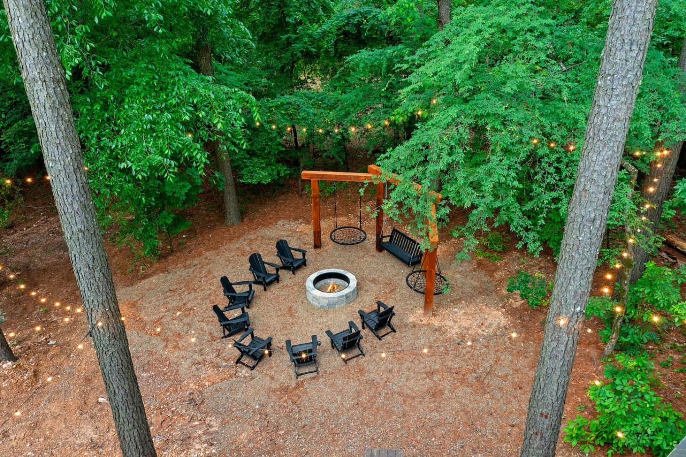 You've got a fire pit, a swing set, some Adirondack chairs, and enough trees around you that it genuinely feels like you're camping—except you're actually comfortable.