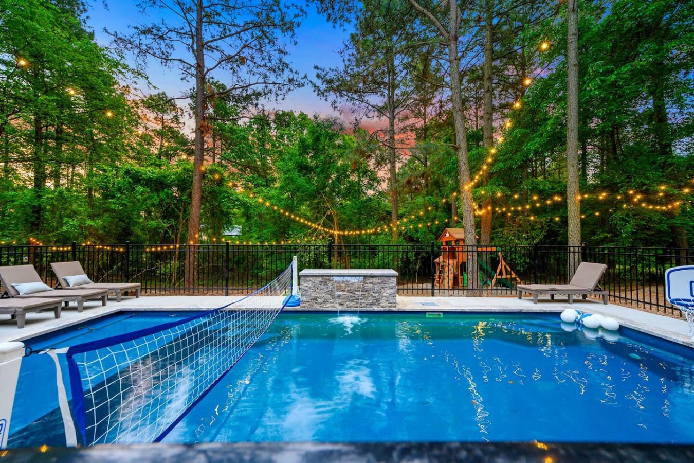 Grab some friends, jump in the pool, and watch the sun set through the trees while those string lights kick in—this is the kind of backyard setup that makes everyone forget their phones exist.