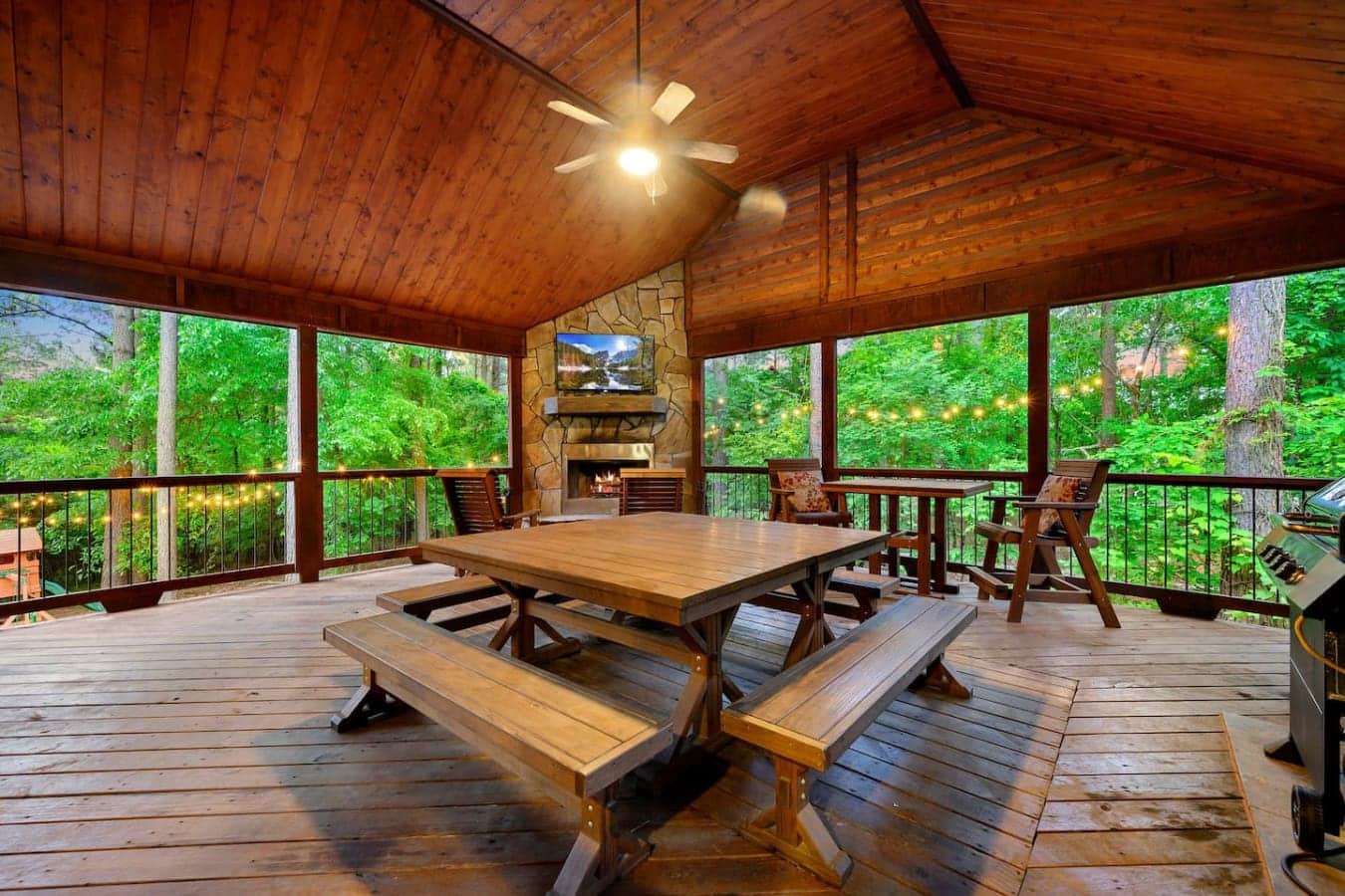 This screened porch has a fireplace, a massive picnic table, and enough windows to feel like you're basically eating dinner outside without actually getting eaten alive by bugs.