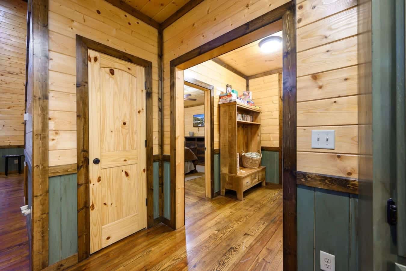 This entryway's got that classic cabin vibe with the wood-beamed doorways and cozy built-ins, so you basically step inside and immediately feel like you've left the real world behind.