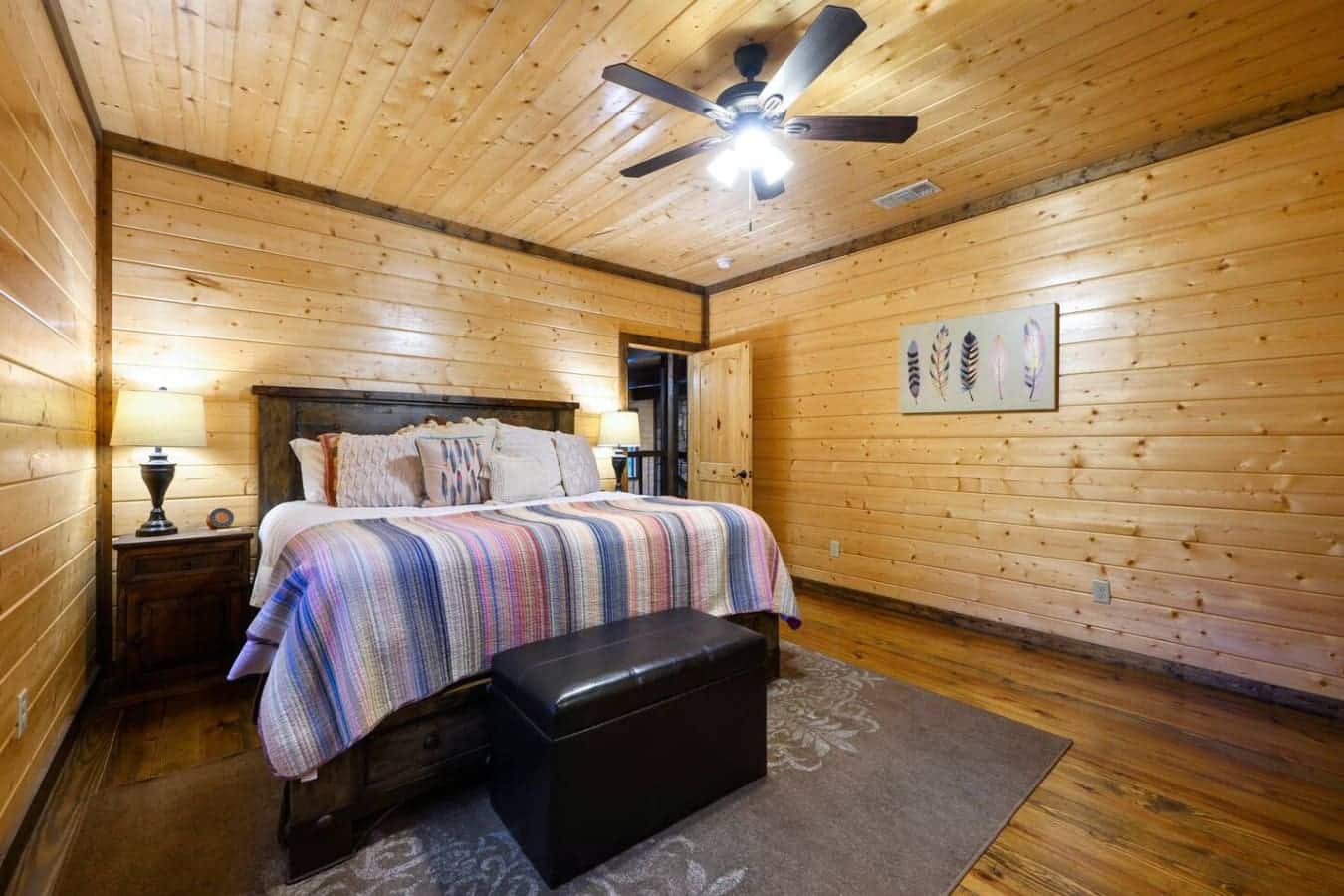 This master bedroom's got that cozy cabin vibe with all the actual comfort stuff—wood everywhere, a real bed that doesn't feel like sleeping on plywood, and enough space to actually move around without tripping over things.