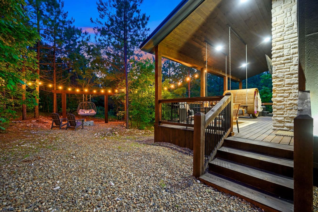 This backyard setup is basically your own private resort—string lights, a fire pit, a hanging chair, and enough space to spread out and actually enjoy being outside for hours.