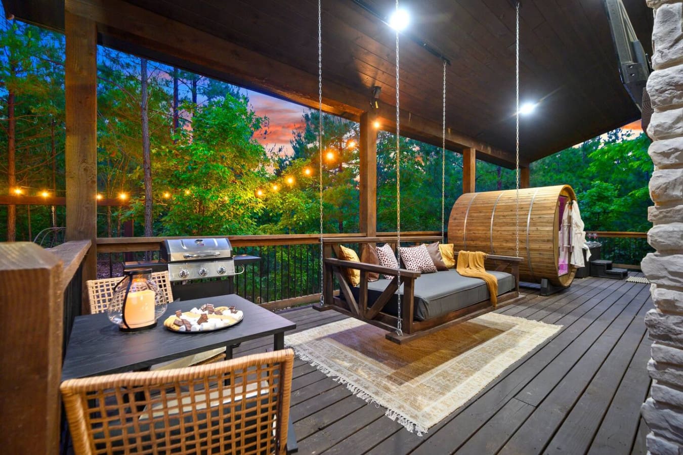 This deck setup has all the right moves—a swing bed for lounging, a grill for cooking, string lights dancing through the trees, and that perfect moment right at dusk when the forest comes alive and you realize you've got the whole peaceful vibe to yoursel