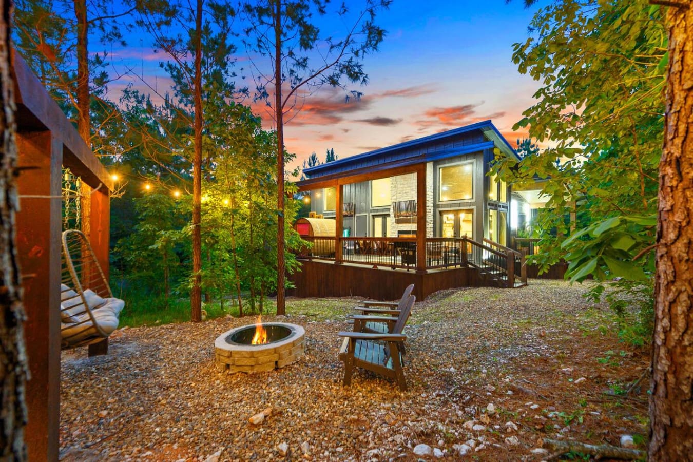 There's something magical about having your own fire pit nestled in the woods, surrounded by tall pines and those glowing cabin windows, where you can literally watch the sunset paint the sky while you're toasting by the flames.