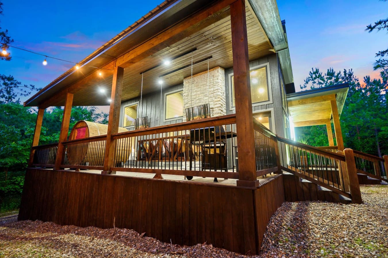 This modern hideaway wrapped in wood and glass is giving off serious "I could actually relax here" energy, especially when the sun dips down and those warm lights kick in against the darkening forest.