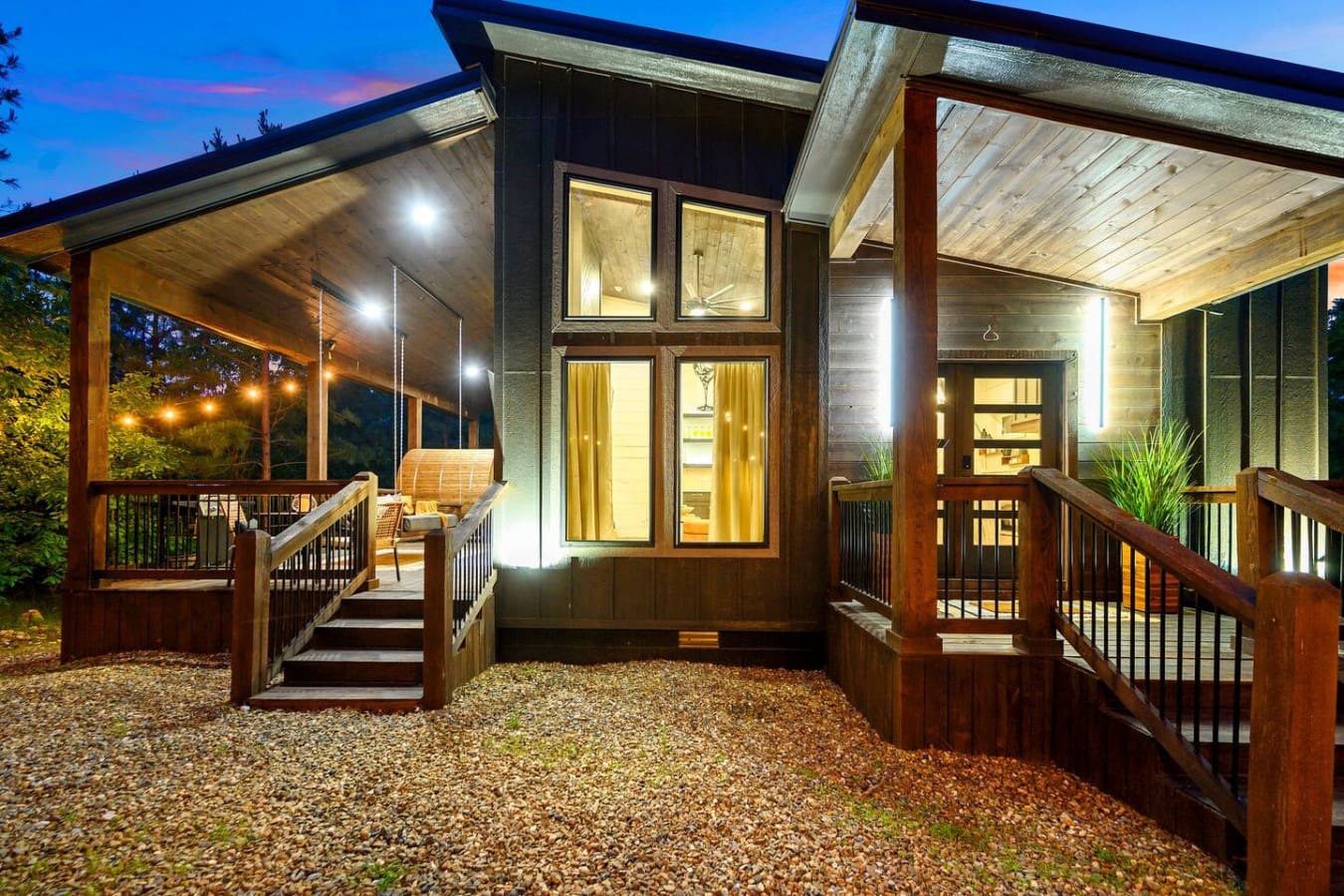 This place is basically built for that perfect twilight moment—all those warm windows glowing against the dark wood while you're standing on the deck with nothing but peaceful forest vibes surrounding you.