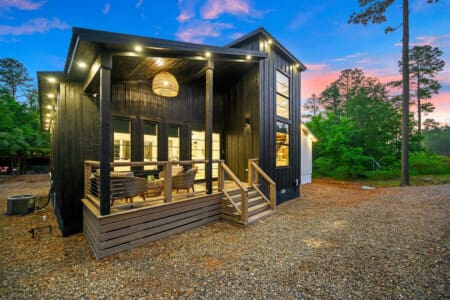 Evenings on the porch never looked so good—where modern design meets peaceful woodland views.