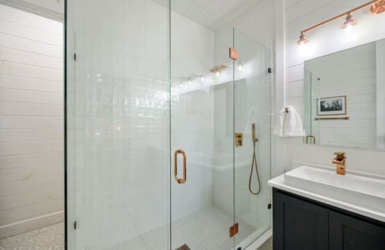 A shower space that shines—crisp lines, warm brass, and spa-day vibes all around.