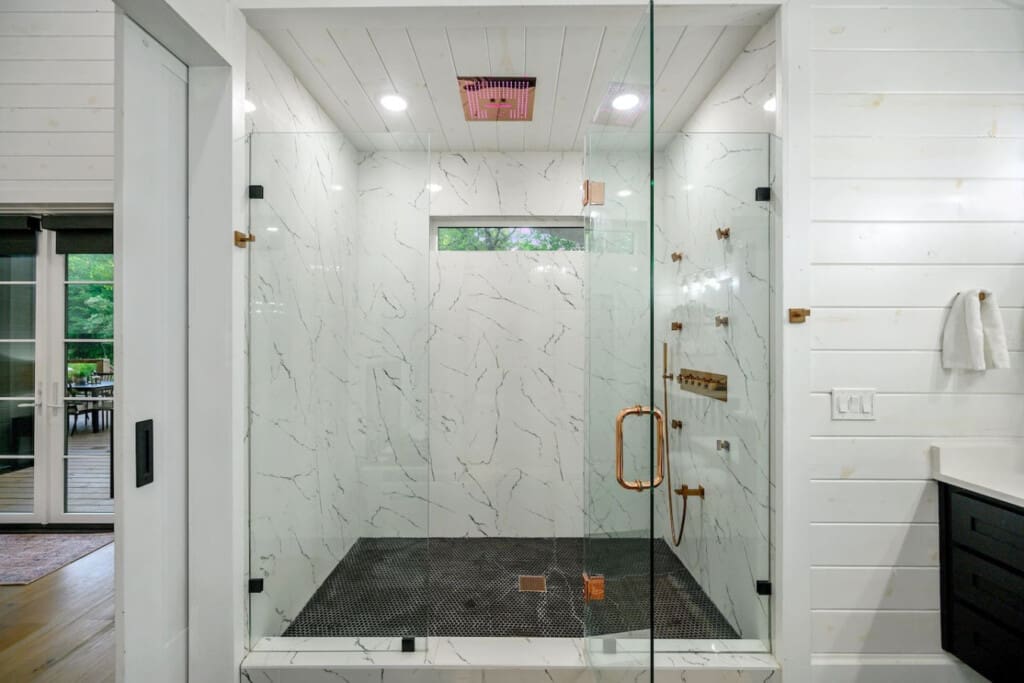 A walk-in retreat with marble walls, copper accents, and a rainfall shower that feels like luxury.