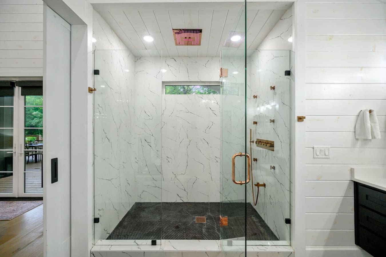 A walk-in retreat with marble walls, copper accents, and a rainfall shower that feels like luxury.