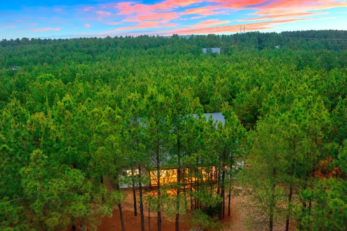 A cabin in the pines, lit from within and crowned by color.