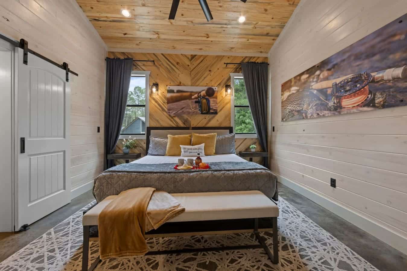 Cozy meets contemporary: this rustic bedroom features warm wood accents, a chevron headboard wall, and inviting modern touches perfect for a relaxing retreat.