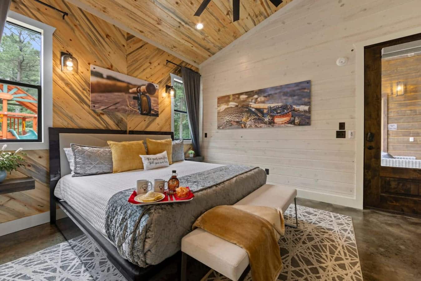 Rustic charm with a touch of luxury: this cozy bedroom showcases natural wood textures, fishing-themed decor, and a breakfast-in-bed setup perfect for a peaceful morning escape.