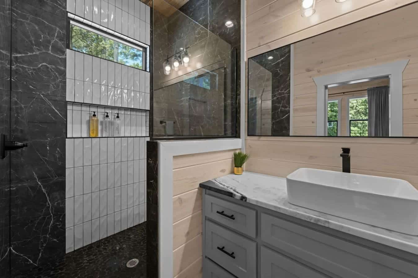 This sleek, spa-style shower at the cabin pairs luxurious design with natural light for the ultimate refresh.