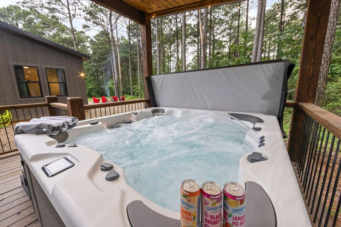 Hot tub + cold drink + forest views = perfect combo.