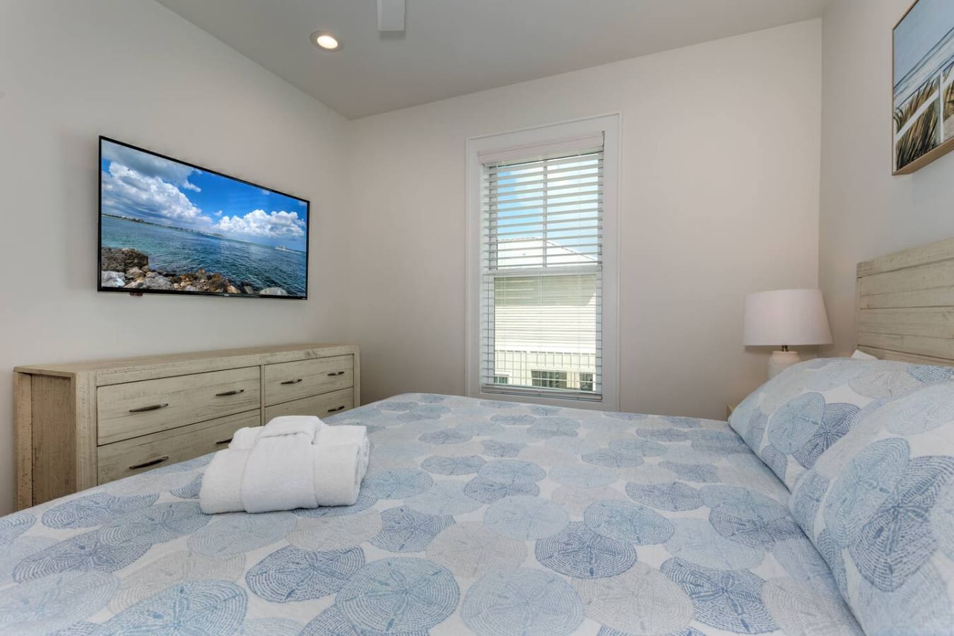 Wake up to ocean views and natural light flooding in through those glass doors—this bedroom basically does all the heavy lifting to make you feel like you're on a proper beach getaway.