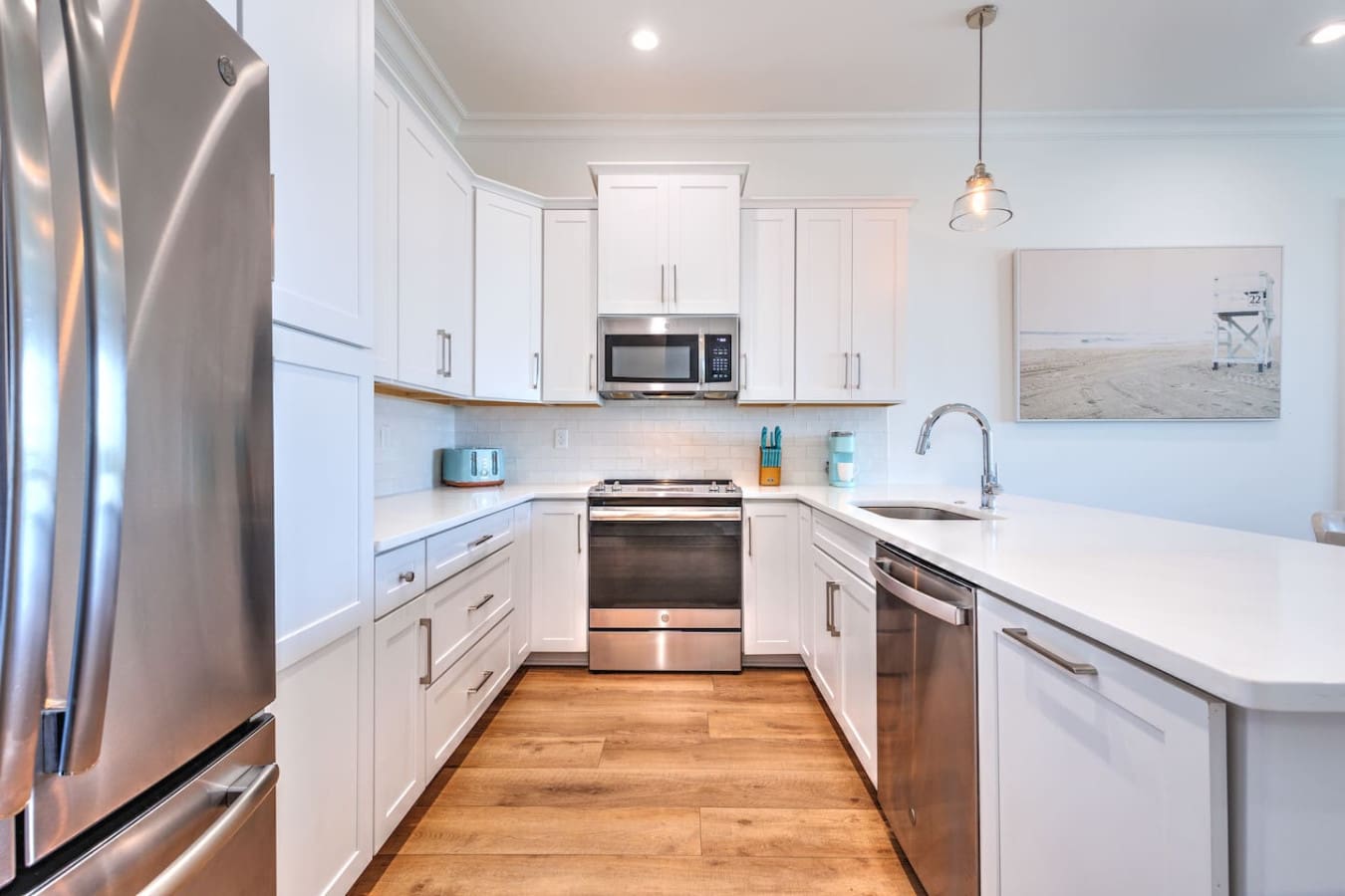 This kitchen's got everything dialed in—modern stainless steel appliances, tons of counter space, and that clean white setup that just makes cooking feel effortless.