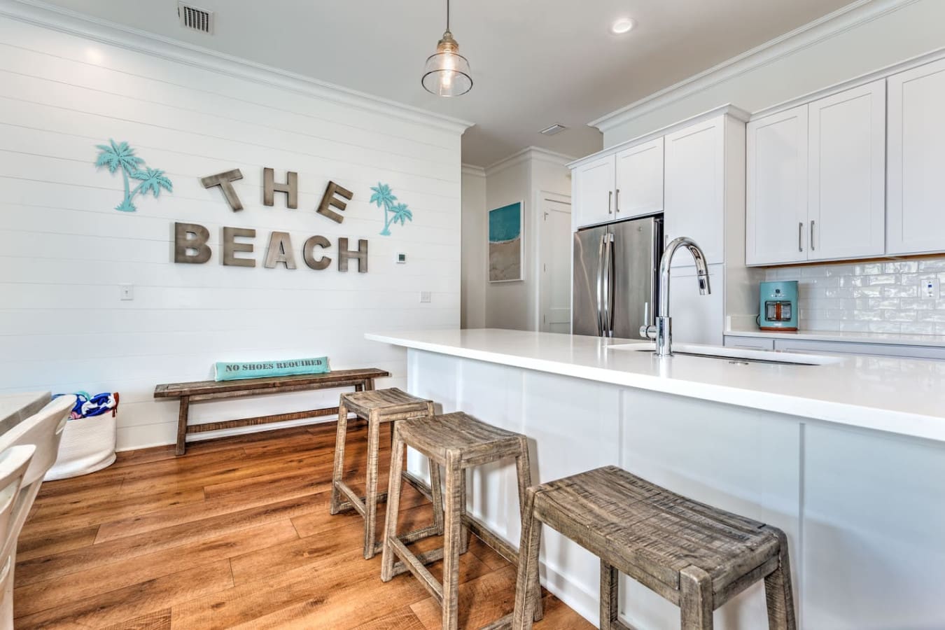 This beachy kitchen is literally screaming "no shoes required" with those weathered bar stools and that giant "THE BEACH" sign taking over the wall.