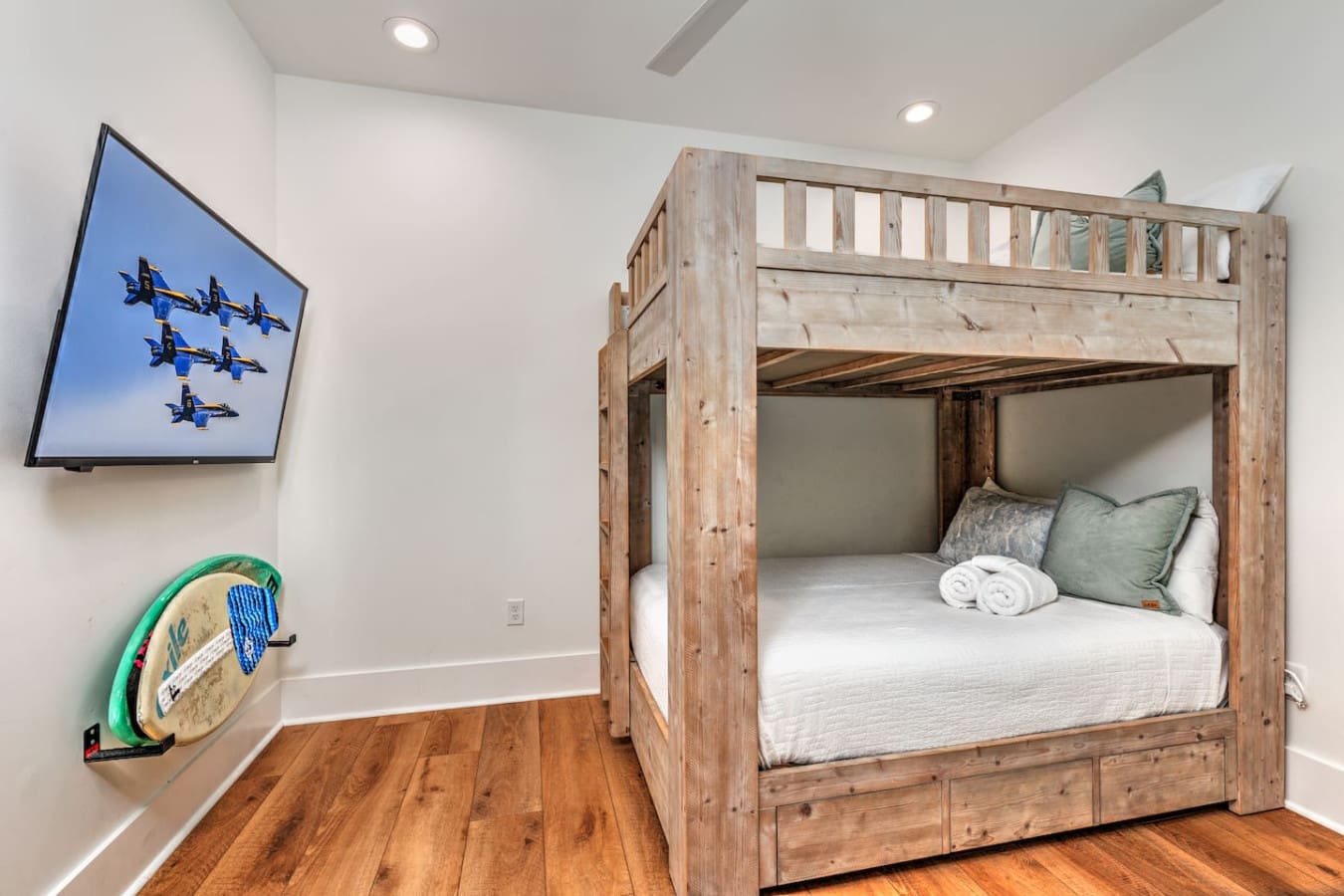 This kids' room has everything—a sturdy loft bed with storage, a TV for downtime, and that awesome wake-board hanging on the wall to keep the beach vibes going strong.