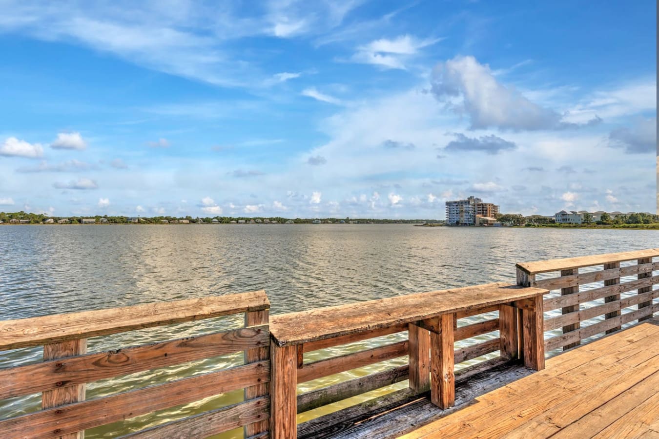 This weathered fishing pier is basically your front-row seat to pure coastal tranquility, with nothing but water, sky, and that perfect blend of marsh and waterfront homes stretching out before you.