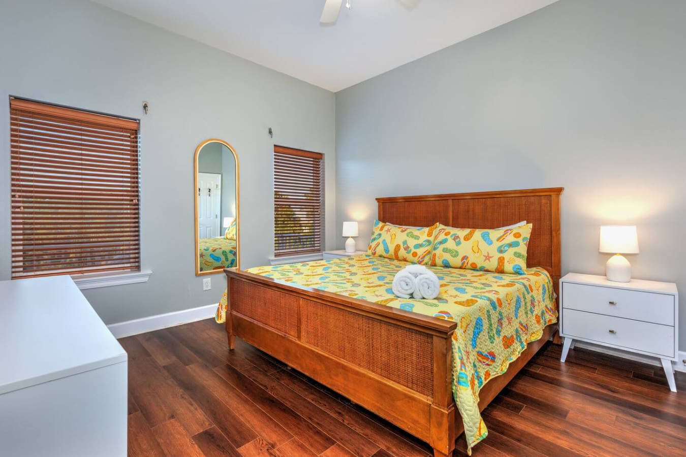 This breezy master bedroom is basically the coastal retreat you've been dreaming about, with those warm wood touches, cheerful ocean-inspired bedding, and soft natural light that makes you want to sleep in all morning.