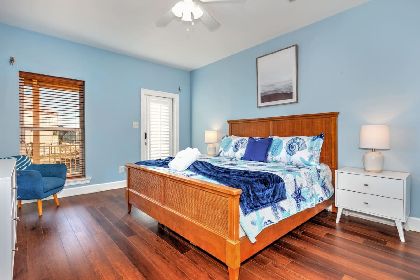 This bright, airy bedroom with its calming blue walls and wooden bed frame feels like the perfect coastal retreat for winding down after a day of beach adventures.