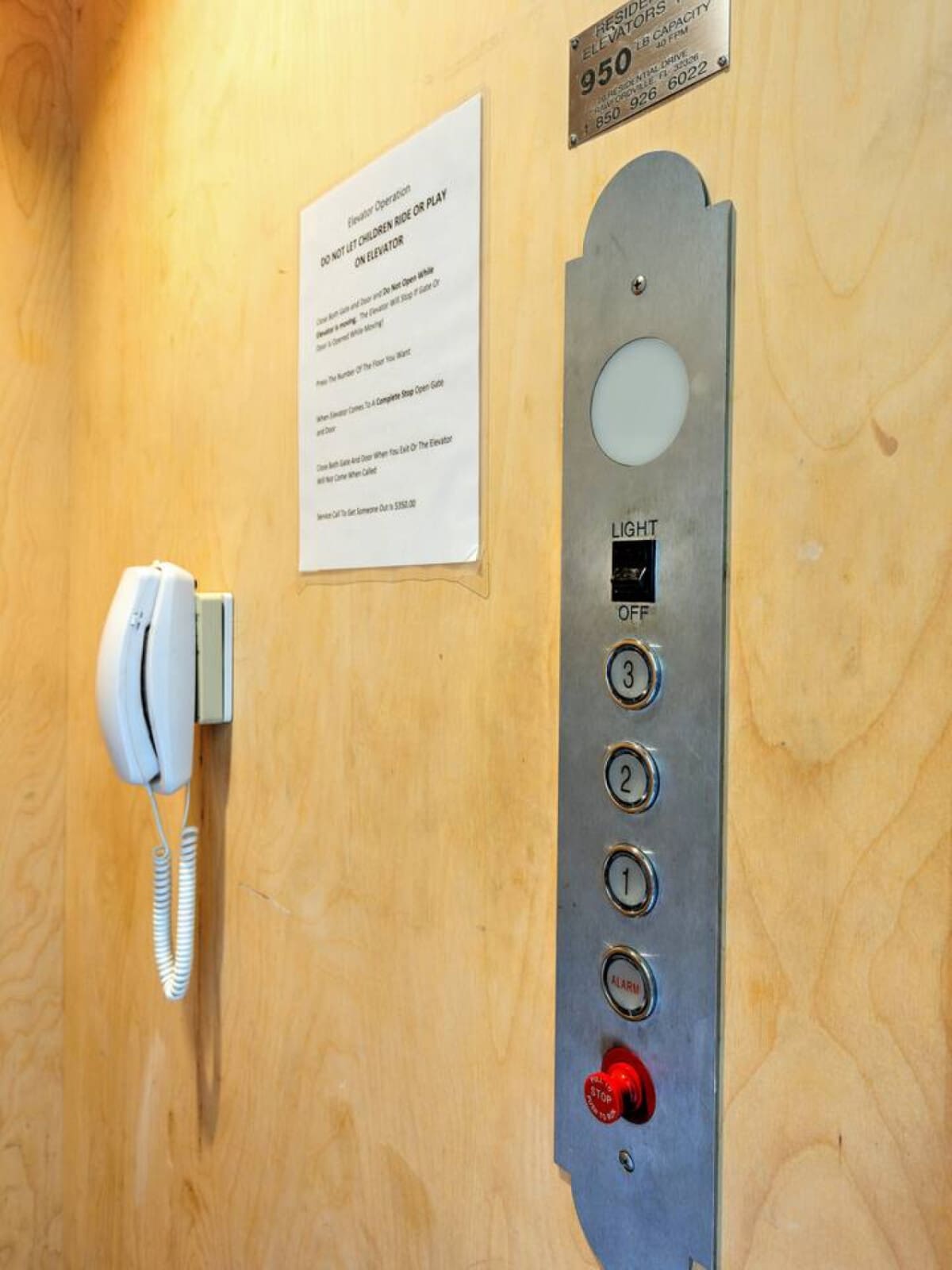 This vintage elevator setup gives me all the charming, nostalgic vibes—complete with that red emergency button and floor bells that'll transport you back in time.