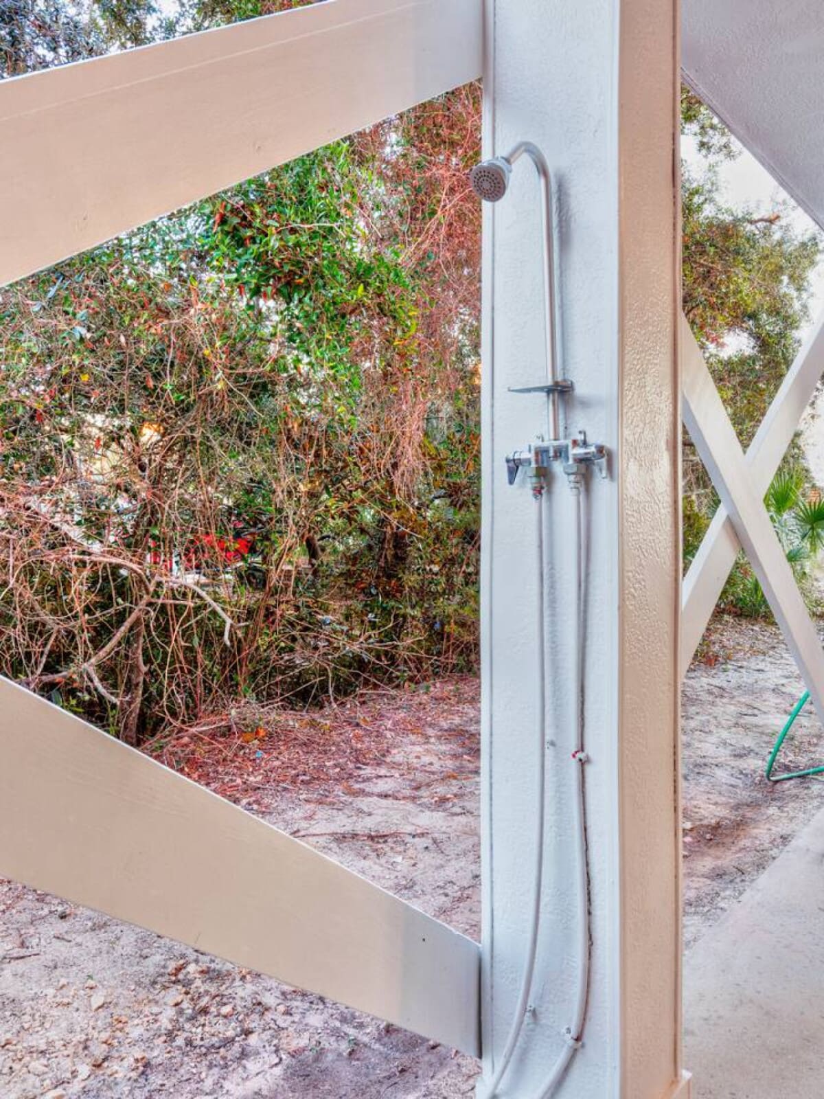 This outdoor shower is the perfect spot to rinse off the sand and salt before heading back inside, with that lush overgrown garden creating the ultimate private oasis vibe.