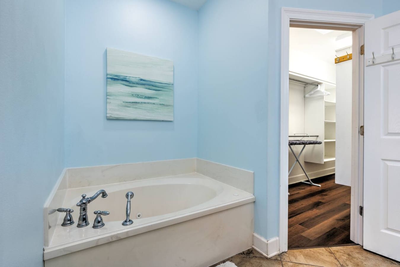 This peaceful soaking tub with those soothing blue walls and a little ocean-inspired artwork is basically your own private spa retreat tucked right into the bathroom.
